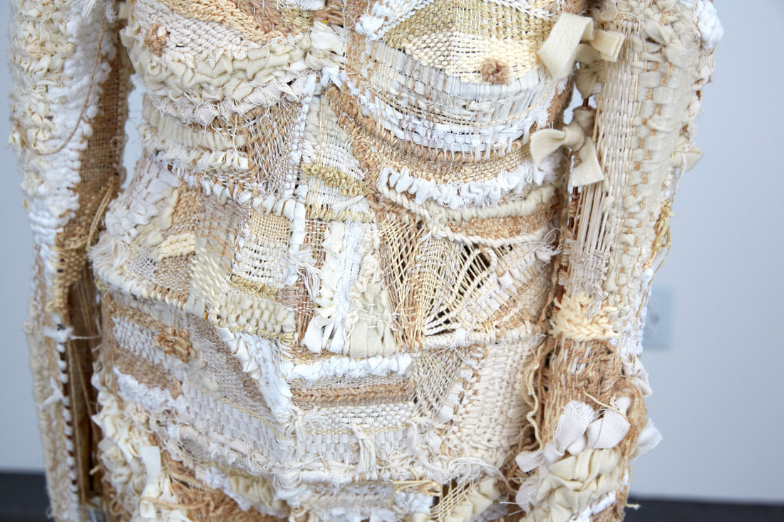 Close up of textile weaving of cream colors creating the skin of a female figurative sculpture